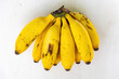 A bunch of fresh ripe yellow bananas on wooden textured white background. Bananas are healthy fruit.