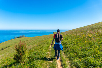 Wall Mural - A tourist walking along a path near the Zumaia flysch, Gipuzkoa. Basque Country