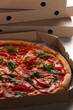 Large Pizza in open carton box on kitchen table closeup view