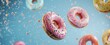 Floating pink donuts with sprinkles on a pastel blue background - a sweet treat suspended in the air
