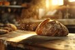 Artisanal bread with flour dust on a wooden board, backlit by warm sunlight in a rustic bakery. Freshly baked bread on wooden table in bakery shop, closeup