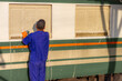 Employees are wiping, washing, inspecting and cleaning trains for use in transporting passengers