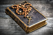 Vintage rosary beads on old Bible