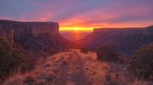 The Sun Setting Behind A Towering Mesa, Painting The Sky In Hues Of Orange And Pinkimage