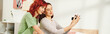 banner of home photo session of happy young lesbian couple taking selfie on retro camera in bedroom