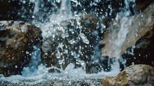A Stream Of Water Cascades Down A Rocky Cliff, Sending Droplets Flying In All Directions As It Crashes Into The Pool Below.