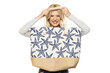 Beautiful young happy blonde woman with beach bag on white background