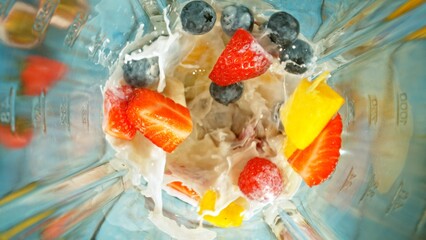 Wall Mural - Freeze motion of mixing pieces of berries in blender with milk, top shot