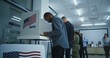 African American man votes in booth in modern polling station office. National Election Day in the United States. Political races of US presidential candidates. Concept of patriotism and civic duty.