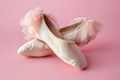 A pair of ballet slippers, poised for dance, isolated on a classical ballet pink background, echoing grace and movement