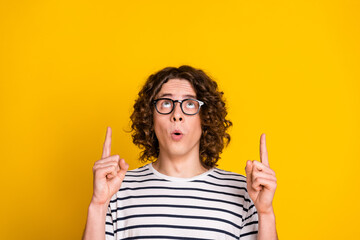 Sticker - Close up photo of young amazed funny nerd guy direct fingers above head much useful information isolated on yellow color background