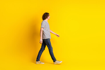 Sticker - Full size profile portrait of nice young man walk empty space wear striped t-shirt isolated on yellow color background