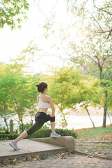 Poster - Female jogger. Fit young Asian woman with sportswear stretching muscle in park before running and enjoying healthy outdoor. Fitness runner girl in public park. Wellness being concept