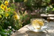 a glass cup of ginger tea against a summer garden