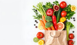 Fototapeta Kuchnia - A variety of colorful fresh vegetables and fruits, such as carrots, broccoli, tomatoes, and apples, are arranged to seem as if they are tumbling out of a brown paper bag, with a clean white BG.