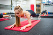 Young sport woman doing exercise in a plank position for the abs at gym, she exercise for strong and good healthy