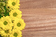 bouquet of yellow flowers, lying as a decoration on wooden surface, space for text