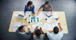 © peopleimages.com - Top view, planning and group of business people in meeting, discussion or brainstorming in creative startup. Above, team and conversation at table with documents, laptop or tablet of graphic designer