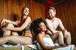 Enjoying a day of pampering. Group of multiethnic happy friends relaxing in the sauna together.