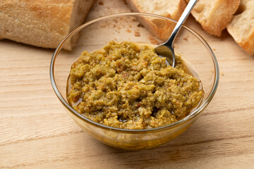 Wall Mural - Glass bowl with traditional homemade green olive tapenade close up