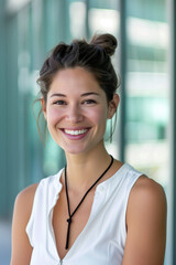 Wall Mural - Woman with a black necklace is smiling. She is wearing a white shirt and has her hair in a bun