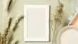 White frame with a blank sheet on a background of beige fabric and plant branches
