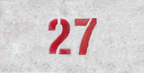 Red Number 27 on the white wall. Spray paint.