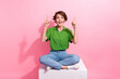 Full body photo of astonished pretty lady sit podium indicate fingers up empty space offer isolated on pink color background