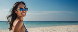 Fototapeta Koty - Young asian beautiful women smiling in swimsuit sunglasses on the beach. Concept, vacation, template, copy space, banner,