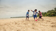 © SALMONNEGRO - Three boys compete for the ball in a soccer game on a beach.
