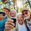 Happy group of young people smiling at camera outdoors - Older friends taking selfie pic with smart mobile phone device - Life style concept with pensioners having fun together on summer holiday 