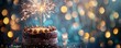 A chocolate cake with sparklers on top and blurred shiny bokeh background. happy new year