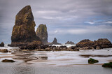 Fototapeta Most - View of several large sea stacks in the ocean at Cannon Beach, Oregon. All sea stacks start out as part of nearby rock formations. Cannon Beach has many examples with haystack Rock as the most famous.