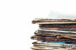 close-up photo of stack of old newspapers laid together, against a clean white background, capturing the nostalgia and charm of vintage print media.