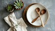 Ceramic tableware set with wooden spoon and plants on surface