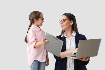 Poster - Little girl with clipboard and her working mother on light background