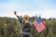 Happy boy holding American USA flag outdoors, people patriotism, 4th of July concept. 