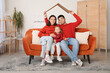 © Pixel-Shot - Happy family with cardboard dreaming about their new house in living room