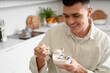 © Pixel-Shot - Young man with tasty yogurt in kitchen, closeup