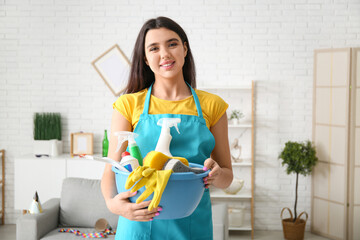 Wall Mural - Young woman with sponge and cleaning supplies in living room