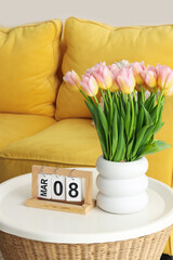 Wall Mural - Calendar with date of International Women's Day and tulips on table in light living room, closeup