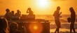 silhouettes at sunset of beach party with dj