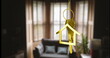 Keychain shaped like a golden house in focus, living room with sofa and plants blurred