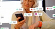Senior Caucasian influencer checking smartphone, icons floating around