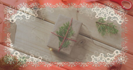 Wall Mural - Two gifts wrapped in cloth lie on pink surface, adorned with pine twigs