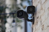 Fototapeta Sypialnia - Closeup shot of outdoor security cameras on a stone wall exterior