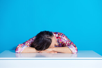 Sticker - Photo of attractive senior woman sit table sleeping put head on hands dressed stylish colorful clothes isolated on blue color background