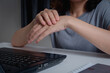 Closeup of woman holding her wrist pain from using a laptop computer long time. Carpal tunnel syndrome or wrist joint inflammation, arthritis, neurological disease, Numbness hand, office syndrome.