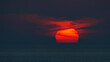 Panoramic sea view, sunset, orange-red sun circle hiding in the clouds, in the dark sky, in the evening