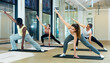 © JackF - Group of young adults maintaining active lifestyle exercising during pilates class in modern fitness center